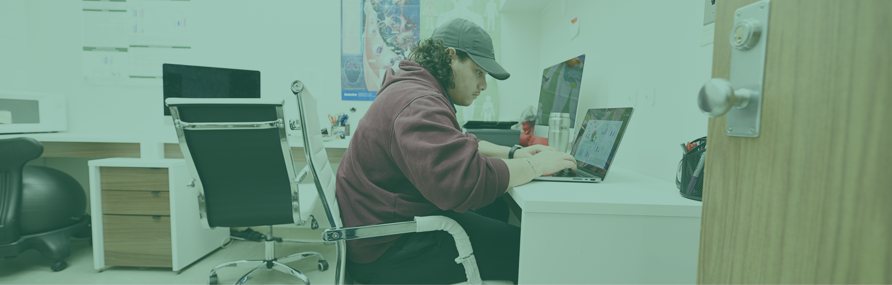 student working on a laptop in an office setting